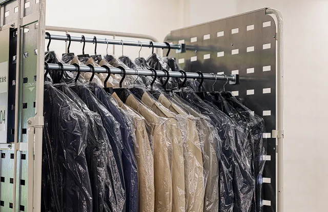 ハンガーカートに吊ったままの衣類を掛け替え作業なしで輸送できる様子を示すアパレル物流のイメージ